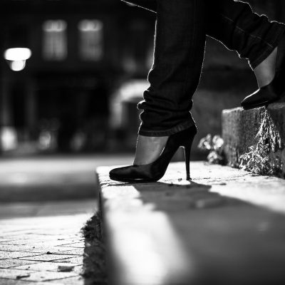 jeune femme portant une paire de jolis escarpins noirs à haut talons gros plan sur les pieds sur les marches d'un escalier rue pavé attente noir et blanc bordeaux mode fashion sebastien huruguen