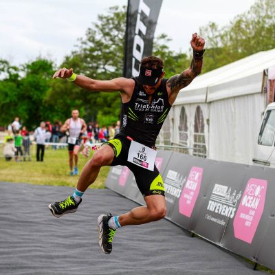 Pierre Serfs (Triathlon Club Montois) termine sa course par un joli saut sur la ligne d'arrivée du Scott Half Triathlon - Lacanau Tri Events 2016 | Sébastien Huruguen www.huruguen.fr